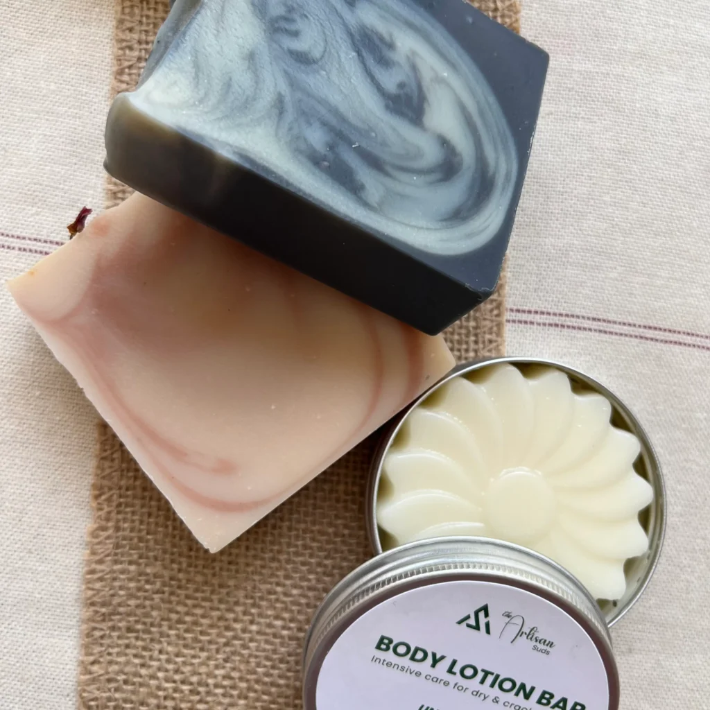 Activated charcoal soap and rose soap bars with an open unscented body lotion bar tin